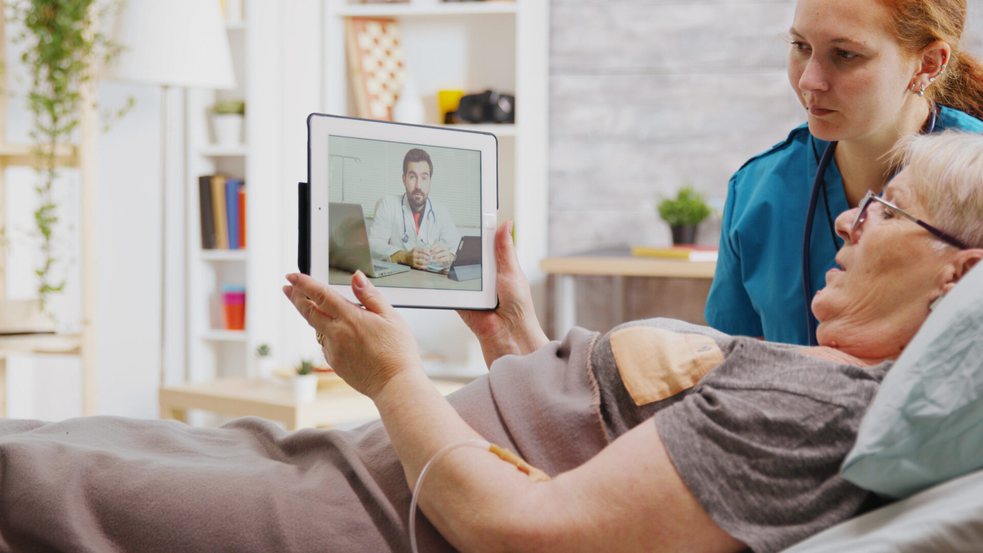 A person holding up an ipad with a video chat on it.