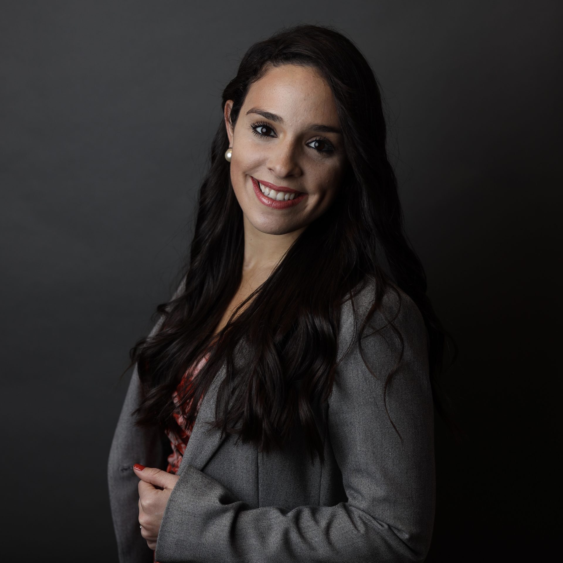 A woman in grey jacket smiling for the camera.