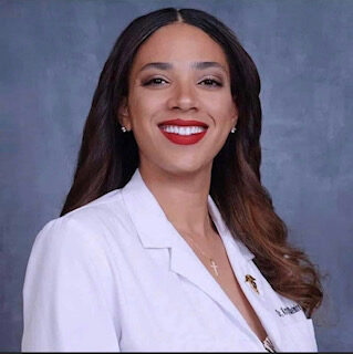 A woman in white jacket smiling for the camera.